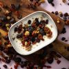 Yoghurt met gedroogde bessenmix op een houten plank