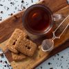 Speculaas thee met speculaasjes en theezeefje op houten plank