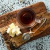 Seizoensthee zomer met theezeefje en nougat op houten plank
