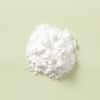 Fijn wit creatine monohydraat poeder op lichtgroene achtergrond