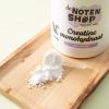 Creatine monohydraat met maatschepje op houten plank