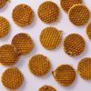 Mini stroopwafels verspreid over lichtpaarse achtergrond