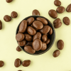 Chocolade rozijnen XXL in een schaaltje op een lichtgele achtergrond