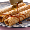 Dadelsiroop geschonken over opgerolde pannenkoeken