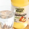 Glas water naast een fles biologische appelazijn