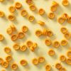 Spicy rings verspreid over een lichtgele achtergrond