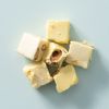 Blokjes soft nougat limoncello met noten op een lichtblauwe achtergrond