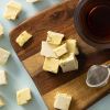 Soft nougat limoncello met noten op een houten plank met thee en een theezeefje