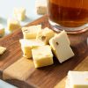 Soft nougat limoncello geserveerd op een houten plank naast een glas thee
