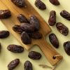 Biologische Medjoul dadels op en rond een houten plank