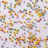 Chocolade smarties mini verspreid over lichtpaarse achtergrond