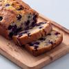 Plakken cake met blauwe bessen op houten plank