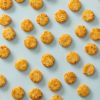 Baked round original crackers los verspreid over een lichtblauwe achtergrond