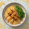 Gerecht met biologische orzo, gegrilde kip, sperziebonen en saus