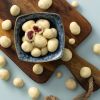 Chocolade yoghurt rozijnen in een blauw schaaltje op een houten plank
