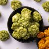 Groene wasabi crackers in een zwart schaaltje met enkele crackers eromheen