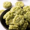 Close-up van groene wasabi crackers in een zwart schaaltje