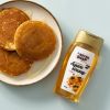 Biologische agavesiroop naast een bord met pannenkoeken