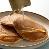 Agavesiroop wordt over een stapel pannenkoeken geschonken