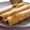 Agavesiroop wordt over opgerolde pannenkoeken geschonken