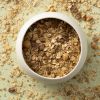 Havermuesli pecan & hazelnoot in een wit schaaltje met muesli eromheen