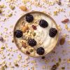 Havermuesli cranberry & amandel op yoghurt met bramen in een rond schaaltje