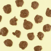 Los verspreide chocolade chips rotsjes melk op gele achtergrond