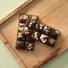Pure chocolade choc block Nuts About Crunch met crunchy bolletjes en stukjes noot op houten plank