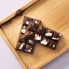 Pure chocolade choc block Tropical Crunch met kokosvlokken en krokante stukjes op houten plank