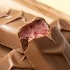 Close-up van Chocolates For You choc bars Red fruit met romige roze roodfruitvulling in melkchocolade
