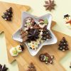 Chocolade kerst figuurtjes in een sterren schaal op een houten kerstboom