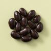 Pure chocolade amandelen in een rondje op een gele achtergrond