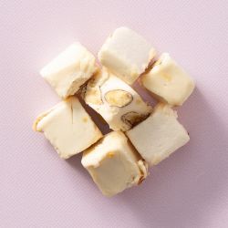 Soft nougat vanille met amandelen op een lichtroze achtergrond