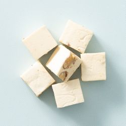Roomnougat met amandelen op een lichtblauwe achtergrond