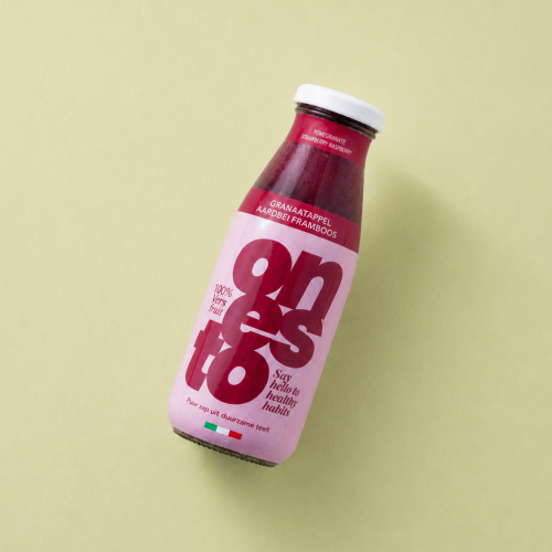 Fles granaatappel aardbei framboos sap op een lichtgele achtergrond Fles granaatappel aardbei framboos sap op een lichtgele achtergrond