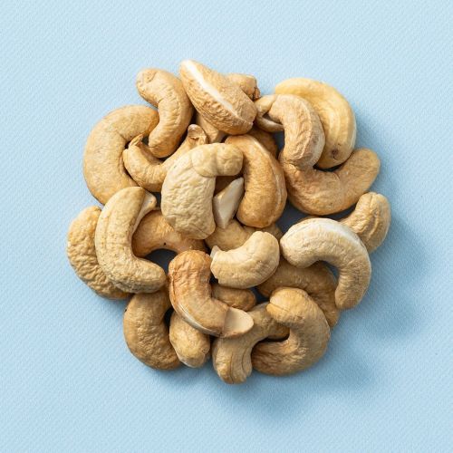 Geroosterde gezouten cashewnoten op een lichtblauwe achtergrond Geroosterde gezouten cashewnoten op een lichtblauwe achtergrond