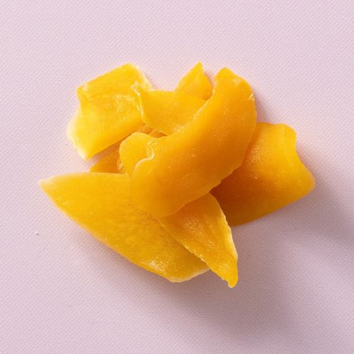 Gedroogde gezoete mango op een lichtpaarse achtergrond