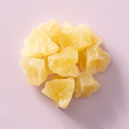 Ananas bites op een lichtpaarse achtergrond Ananas bites op een lichtpaarse achtergrond