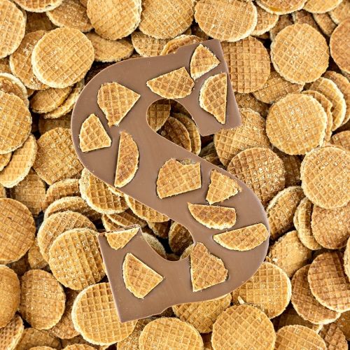 Chocoladeletter stroopwafel met een achtergrond van mini stroopwafeltjes