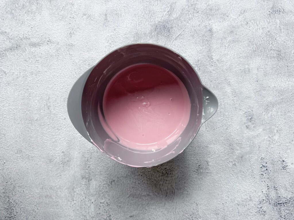 Gesmolten chocolade in een kom met roze kleurstof